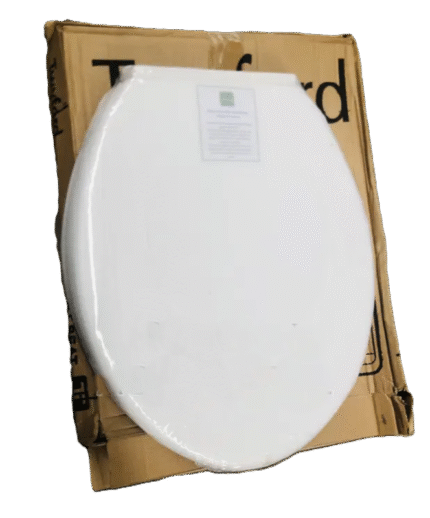 A product photo showing a new, white plastic toilet seat with an oval shape, still wrapped in clear plastic. It is leaning against its brown cardboard box. The text "Twyford" and "SEAT" is partially visible on the box.